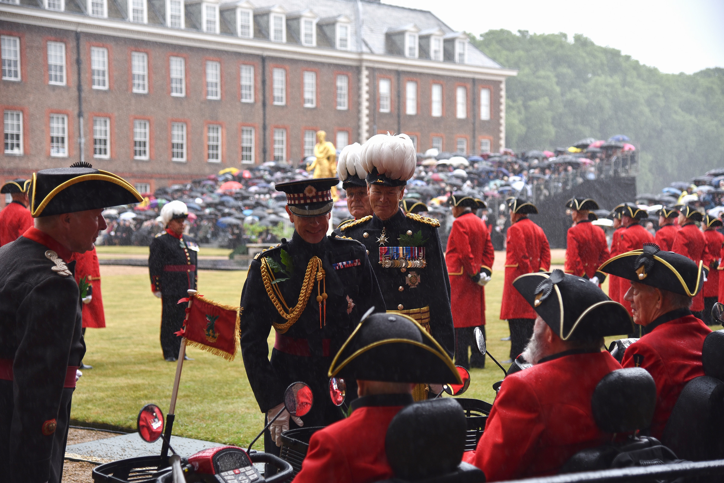 His Royal Highness The Duke of Edinburgh stands alongside the Governor of The Royal Hospital Chelsea, Sir Adrian Bradshaw on figure court in pouring rain as they review the Chelsea Pensioners at Founder's Day 2025