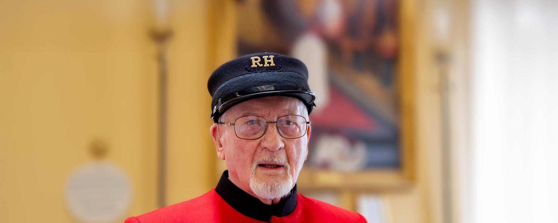 VE Day veteran, Brian Howarth stands in his iconic scarlet coat and shako hat